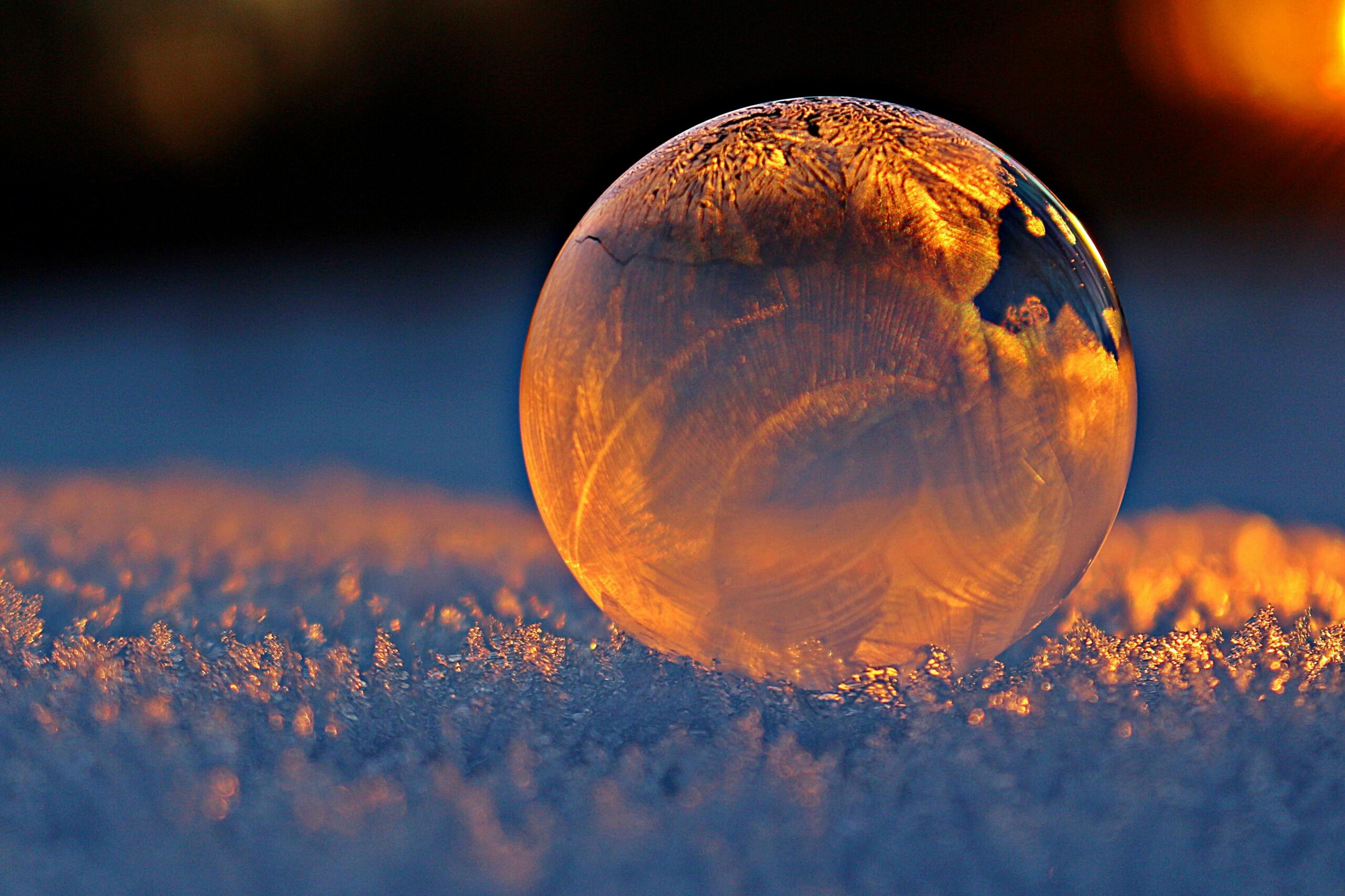 A clear sphere on a frozen backdrop in sunset